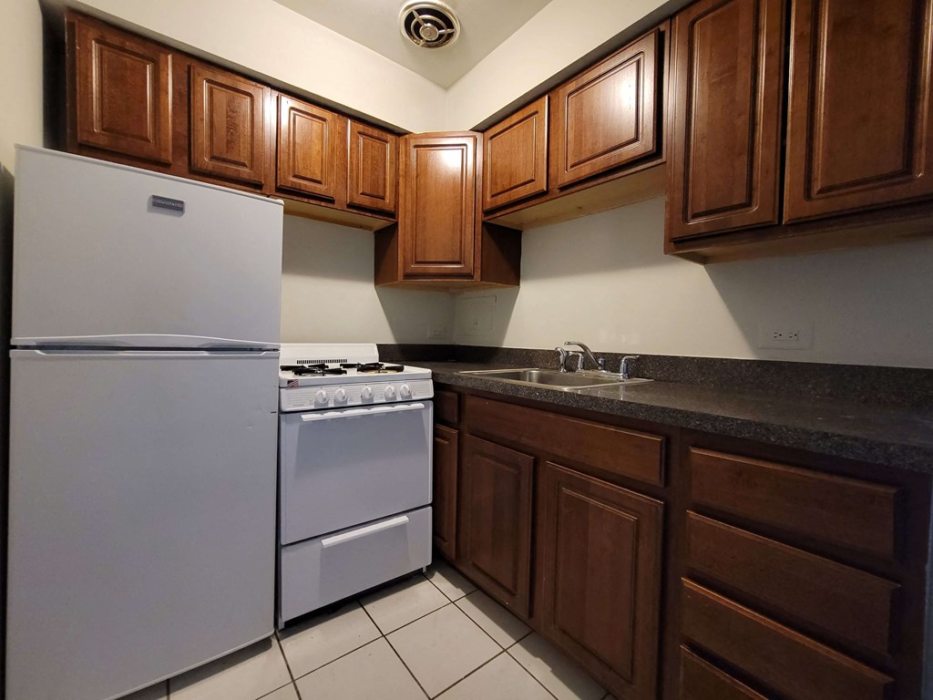 a kitchen with white appliances and wooden cabinets