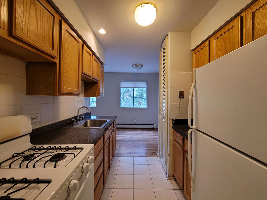 a kitchen with white appliances and wooden cabinets