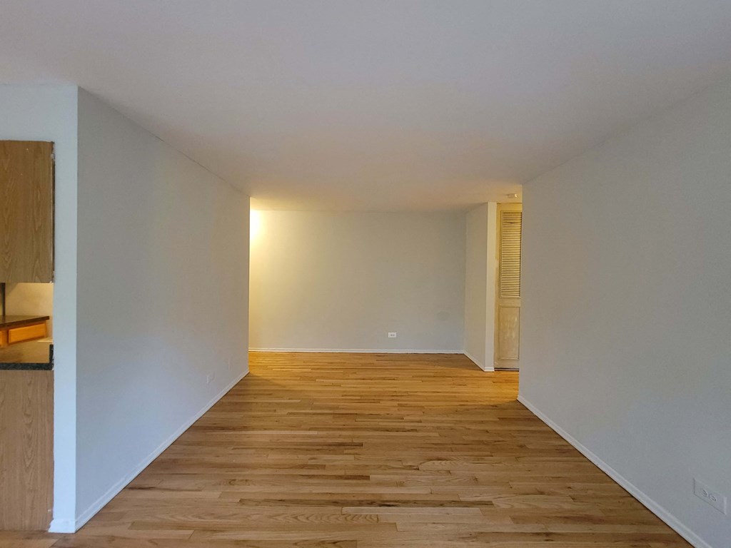an empty room with wooden floors and white walls