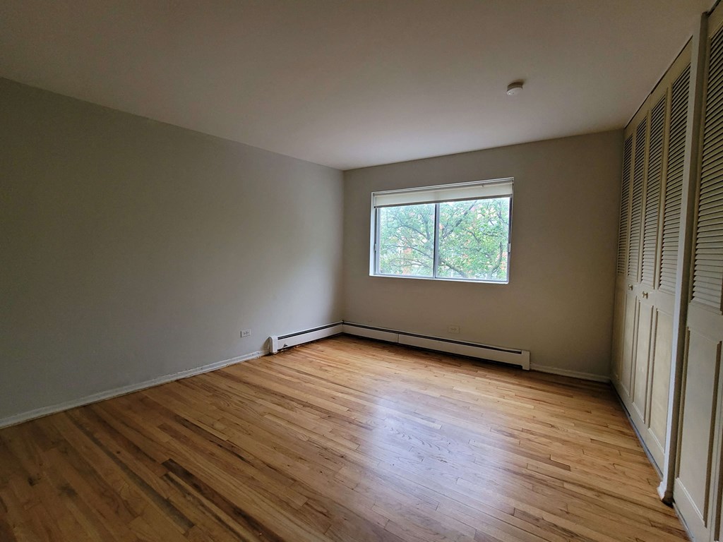 the living room of a house with wooden floors and a window