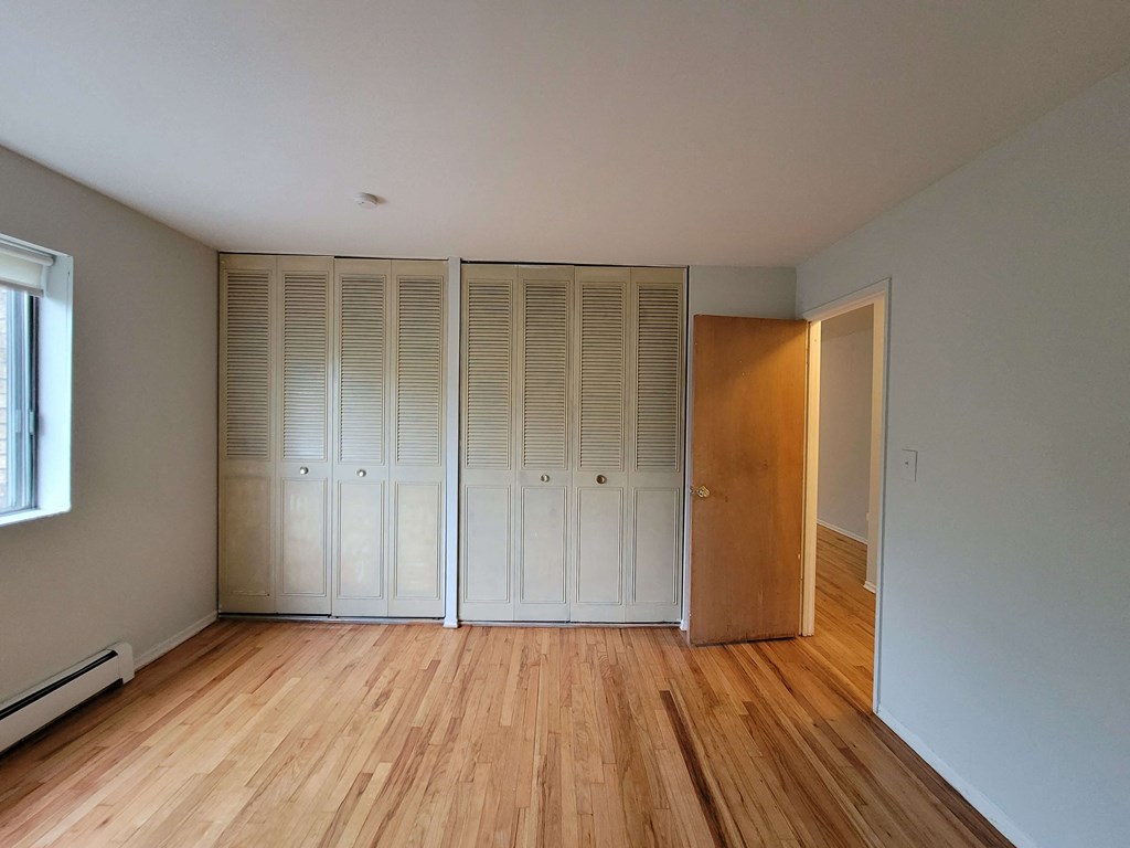 a bedroom with two closets and a wood floor