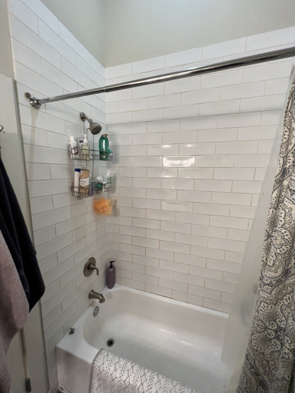 a small bathroom with a tub and a shower curtain