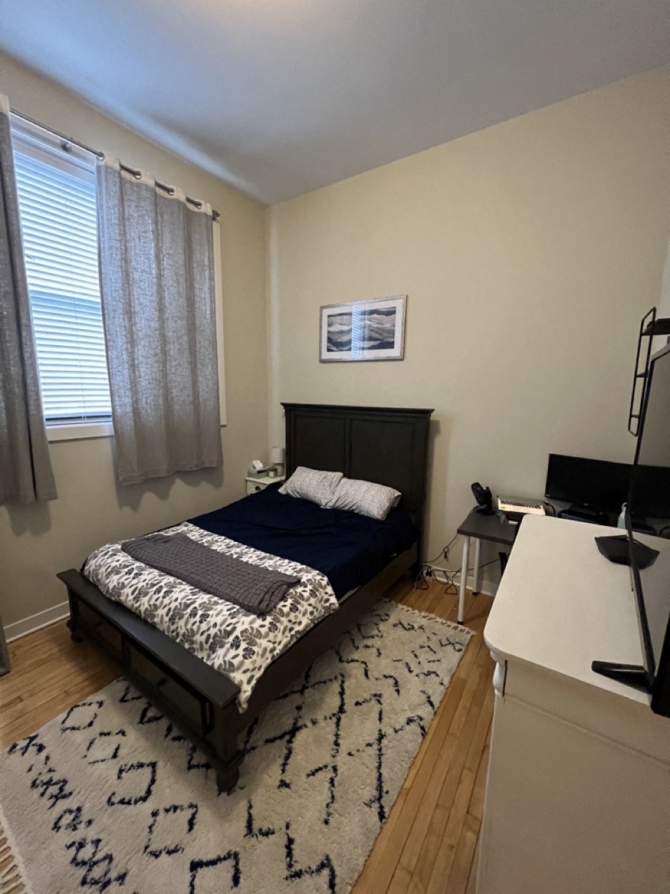 a bedroom with a bed and a desk and a window