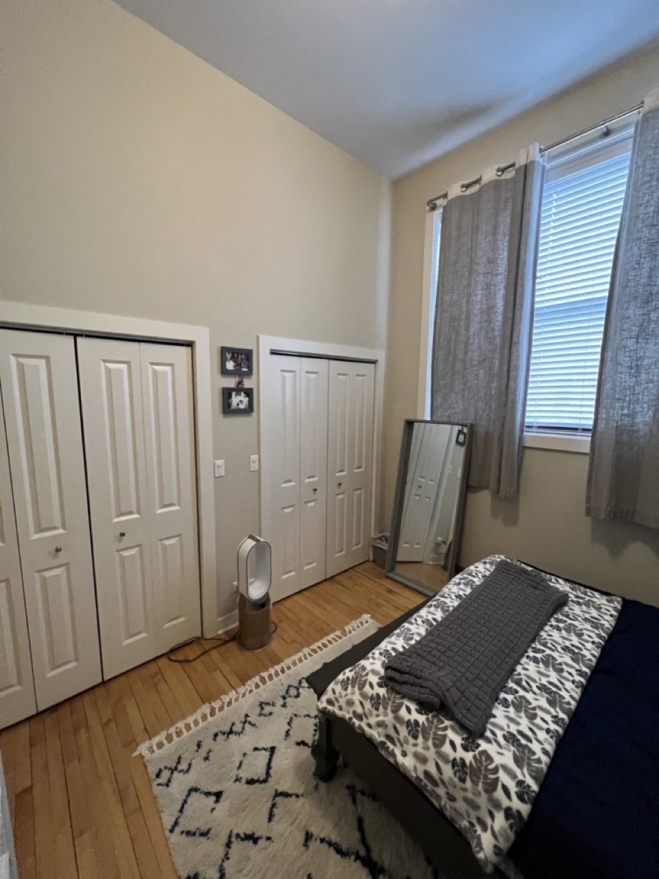 a bedroom with a bed and a rug and two closets