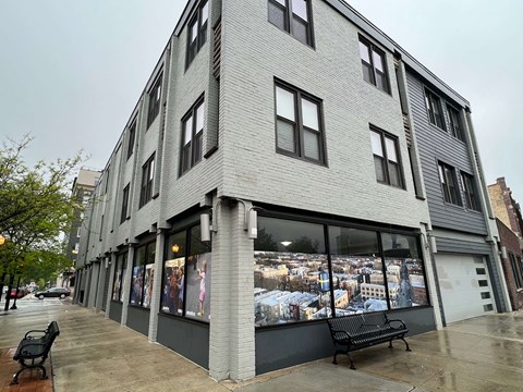 A grey building with a bench in front of it.