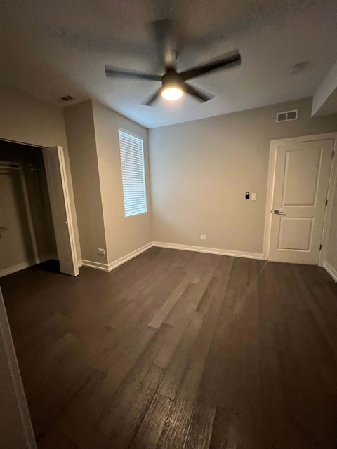 an empty living room with a ceiling fan and hardwood floors