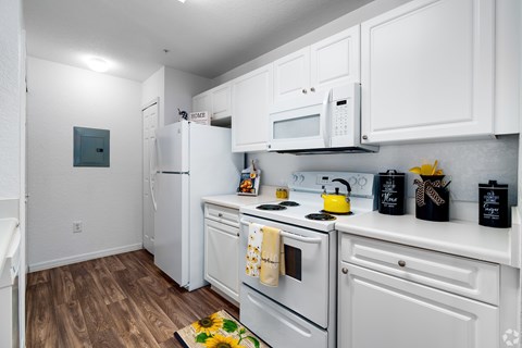 A kitchen with white cabinets and appliances.