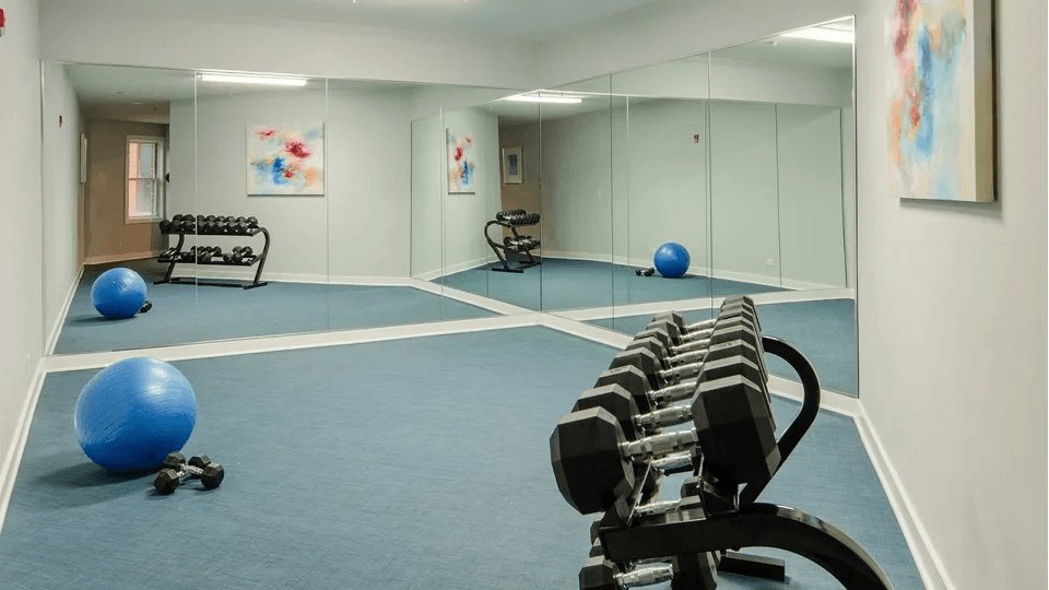 A gym with blue flooring and exercise equipment.