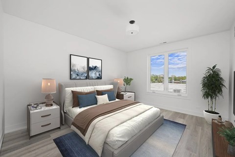 A well-lit bedroom with a large bed and a potted plant.