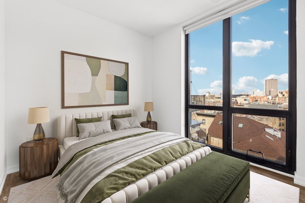 A bedroom with a large bed and a painting on the wall.