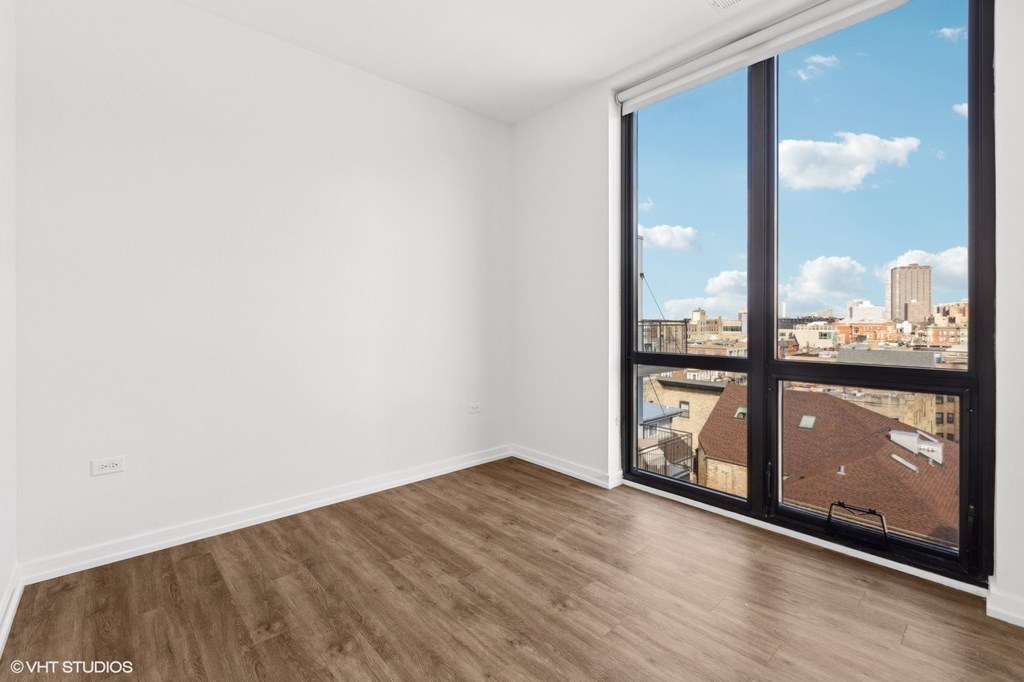 A room with a large window overlooking a cityscape.