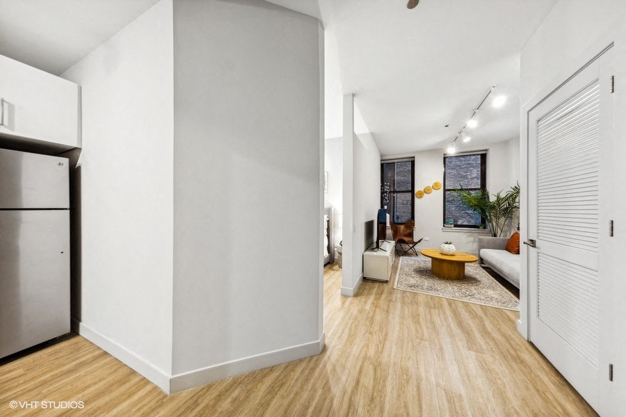 a living room with a refrigerator and a couch