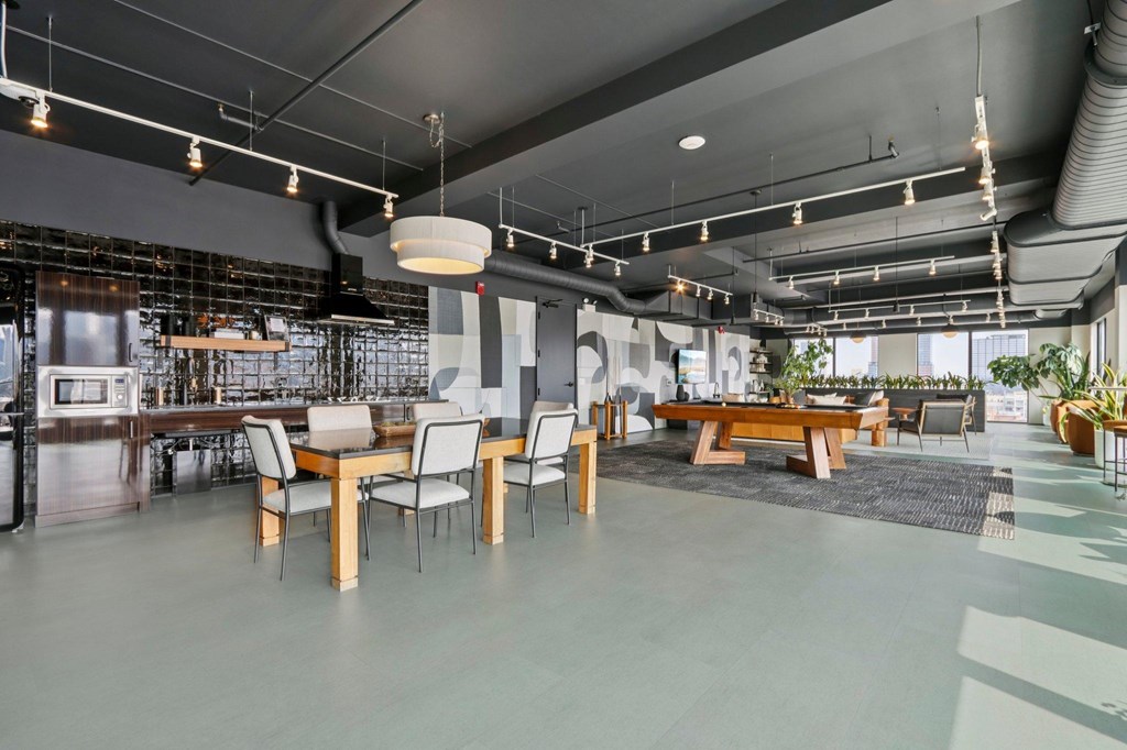 A modern open plan office with a kitchen area and meeting rooms.