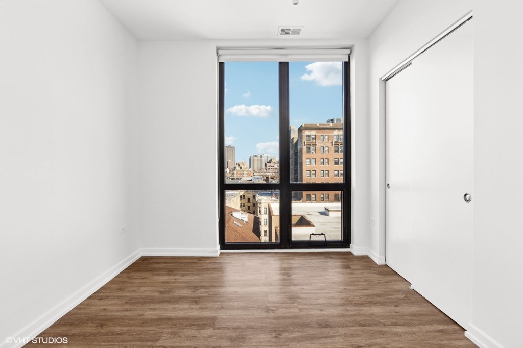 A room with a large window and a wooden floor.