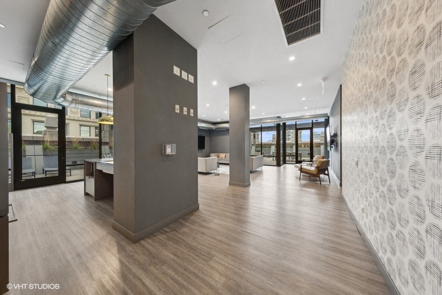 a large lobby with wood floors and glass doors