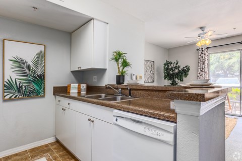 A kitchen with white cabinets and a brown countertop.