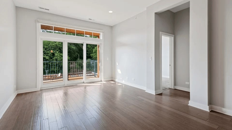 A room with a sliding glass door leading to a balcony.