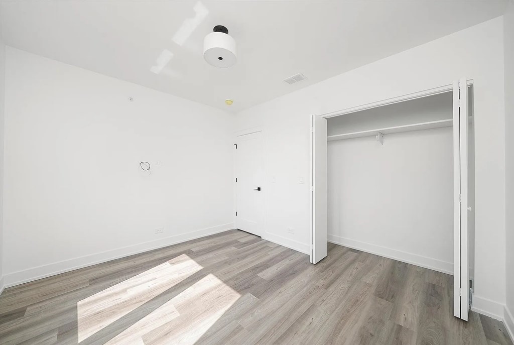 A room with a smoke detector on the ceiling and a door on the right.