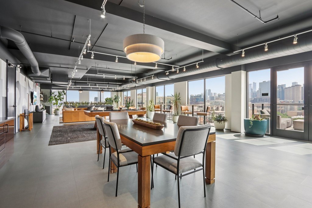A modern dining room with a long table and chairs.