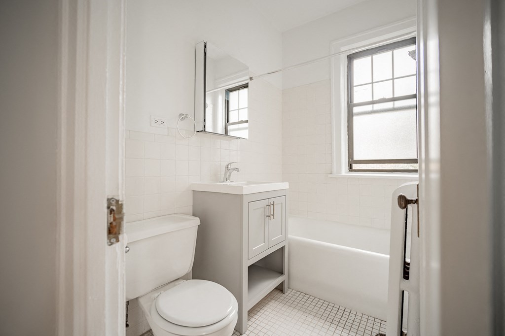 a white bathroom with a toilet and a sink