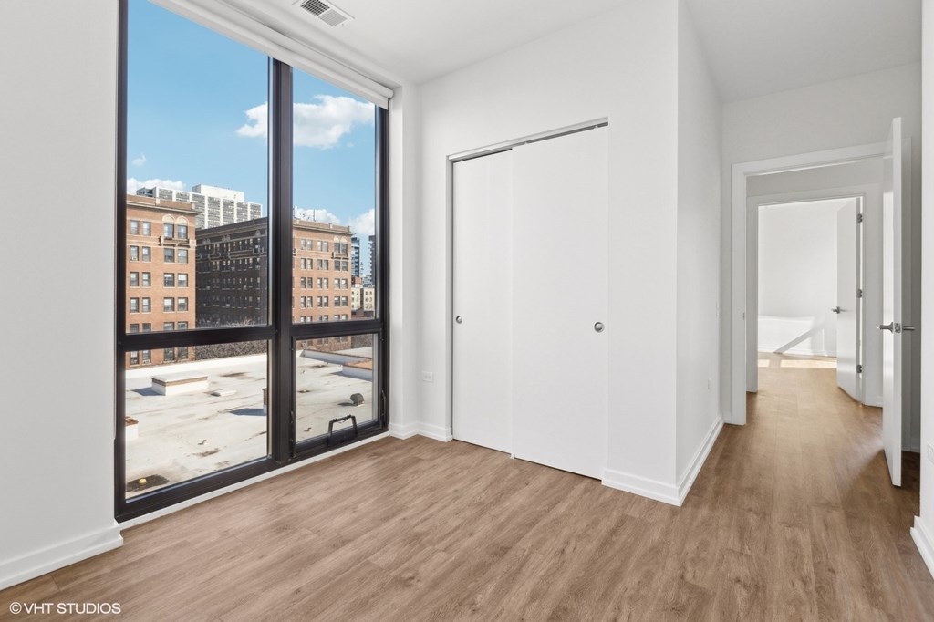 A room with a view of a cityscape through a large window.