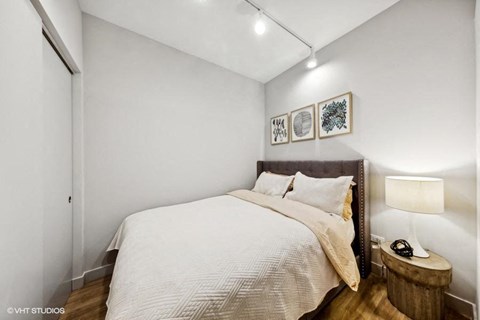 a bedroom with a bed and a night stand