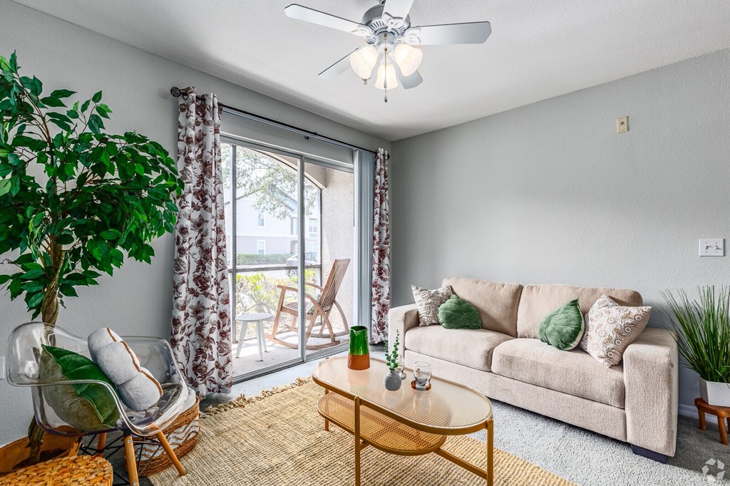 A living room with a couch, a chair, a table, and a plant.