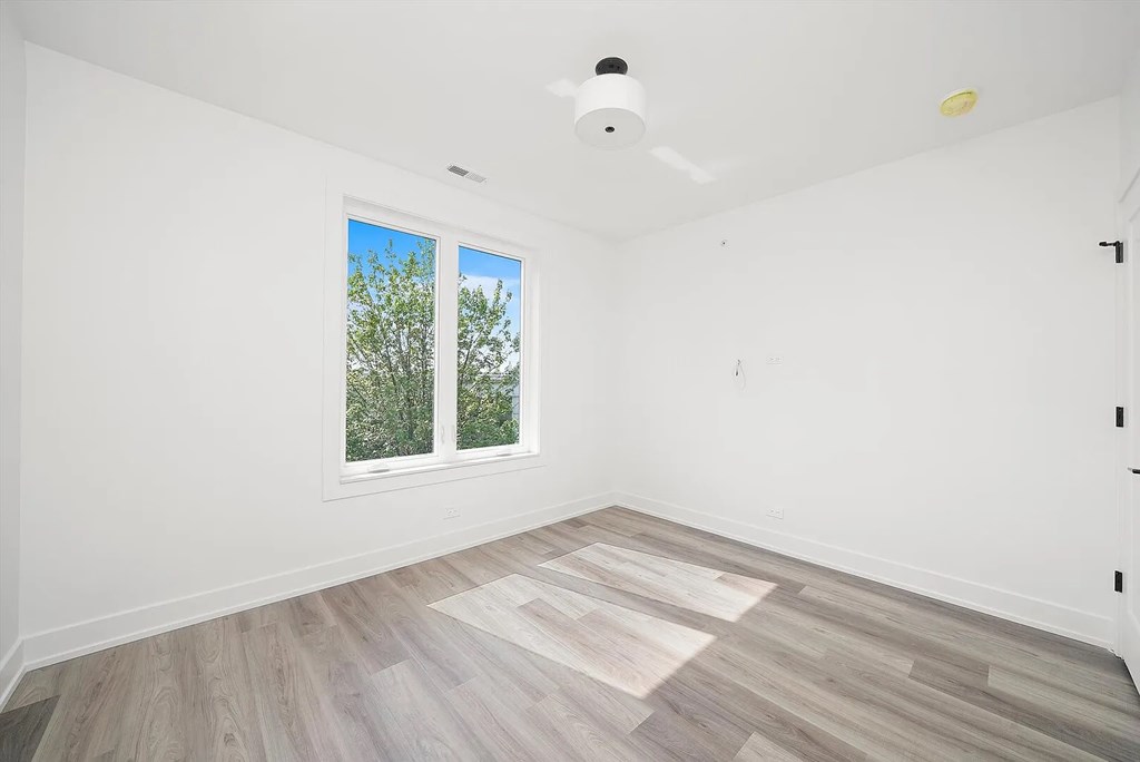 A room with a window and wooden flooring.