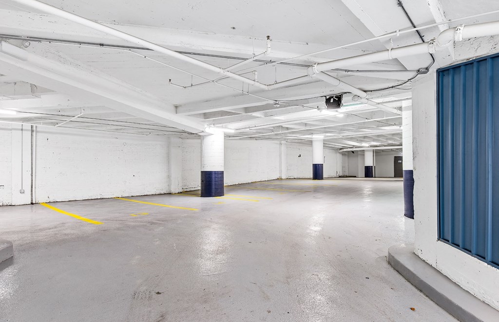 an empty parking garage with white walls and a blue curtain