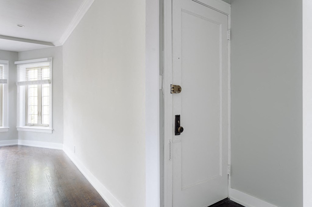 a room with white walls and a white door with a black door knob