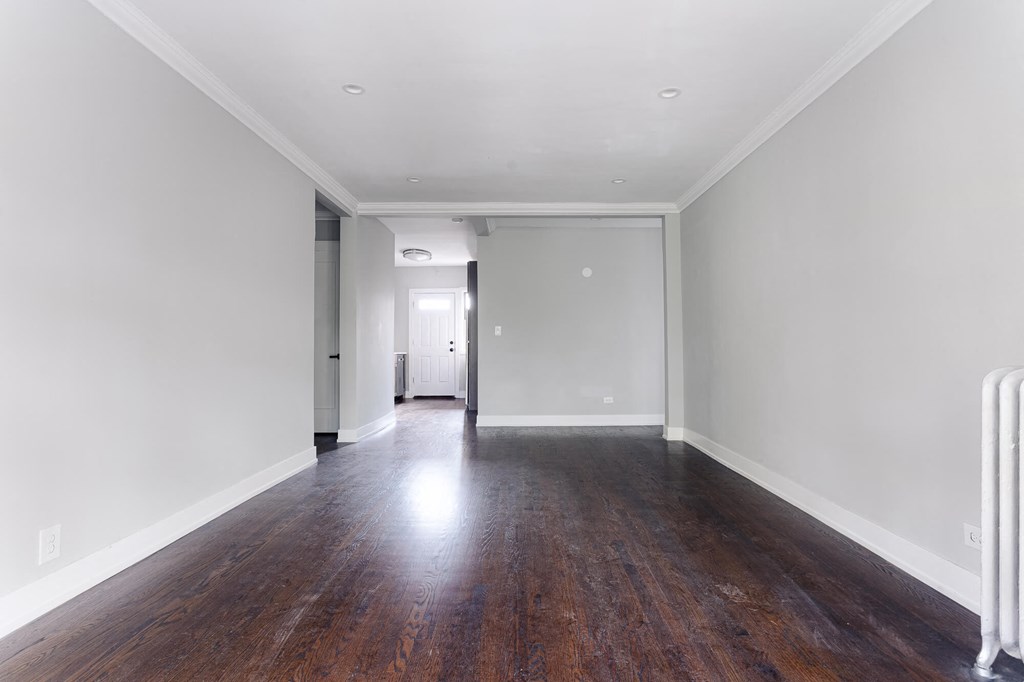 a living room with white walls and wood floors