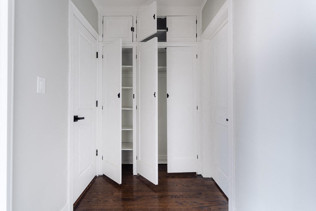 a row of white closet doors in a room with wood floors