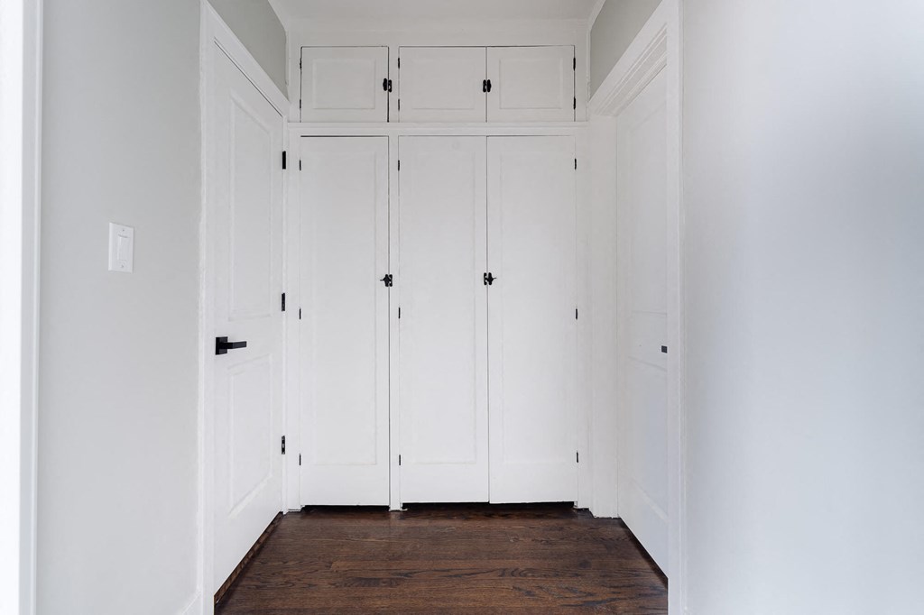a row of white closets in a room with wood floors
