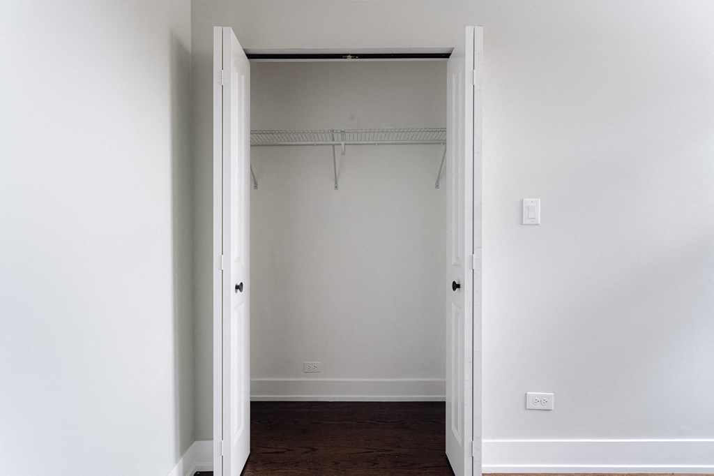 an empty closet in a room with white walls and a wood floor