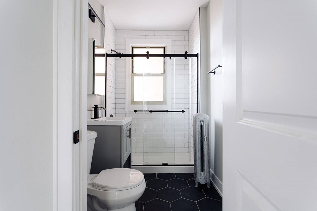 a white bathroom with a toilet and a shower