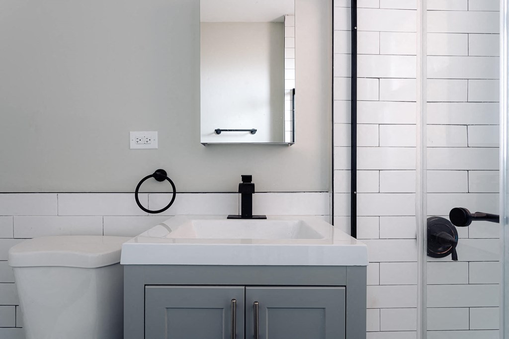 a white bathroom with a sink and a mirror