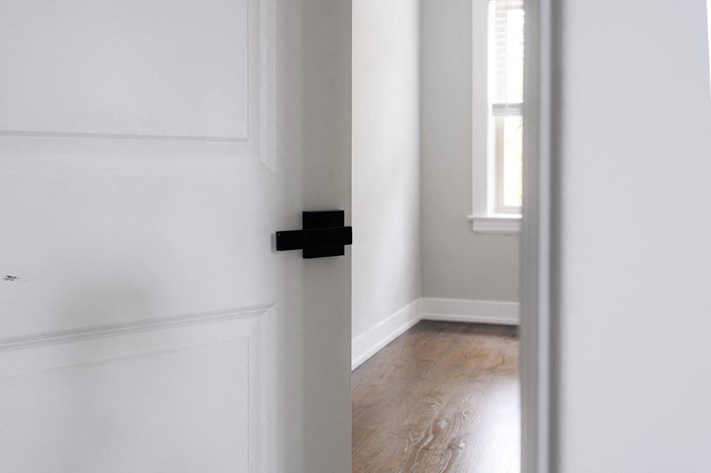 an empty room with white walls and a door with a black door handle