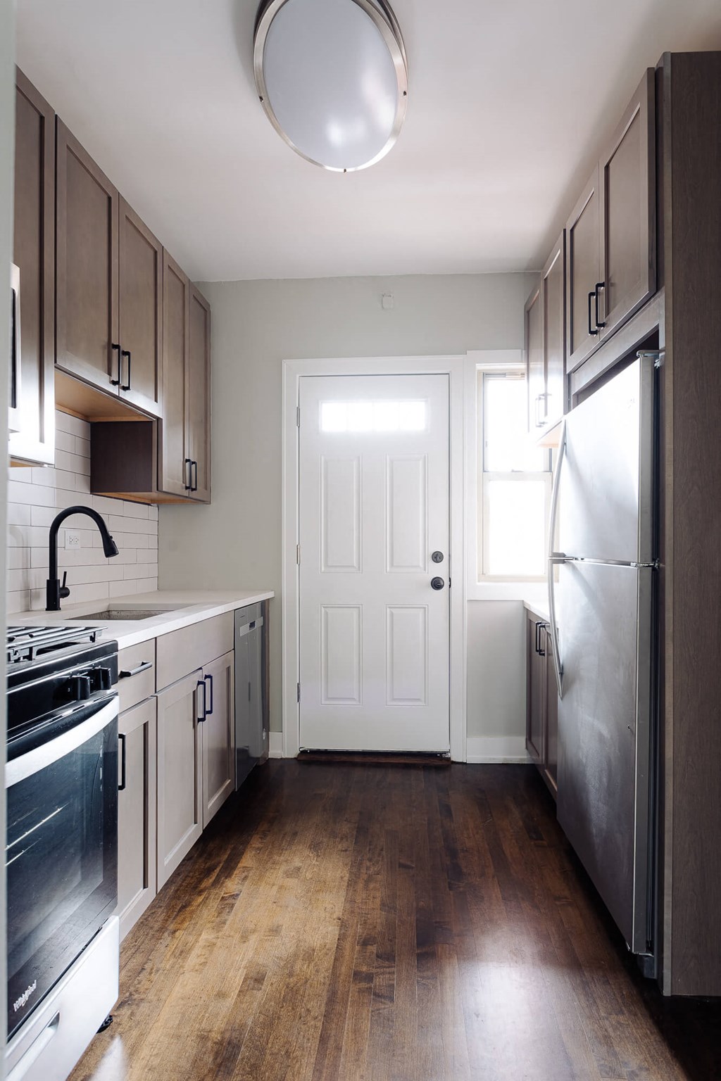 a kitchen with stainless steel appliances and wooden floors
