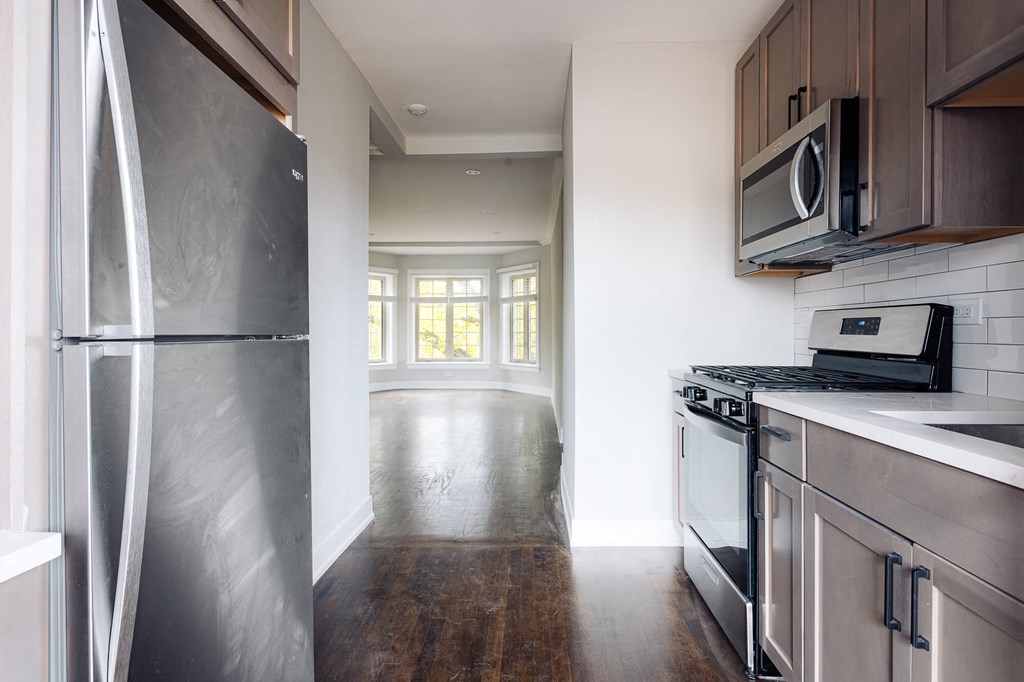 a kitchen with stainless steel appliances and white walls