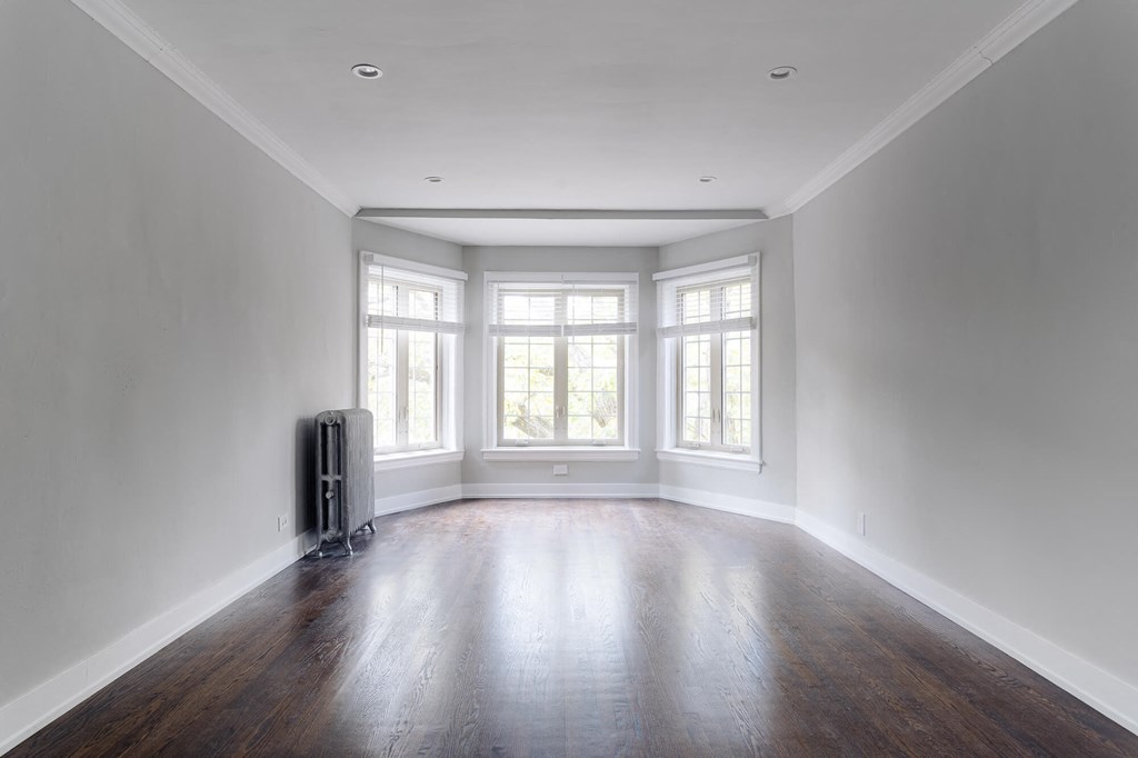 an empty living room with white walls and a large window