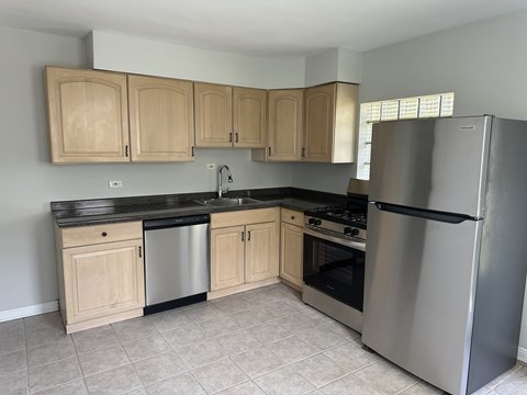 A kitchen with a stainless steel refrigerator, oven, and cabinets.
