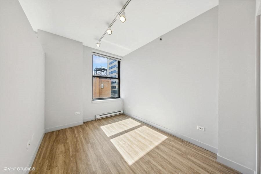 an empty room with a window and wood floors