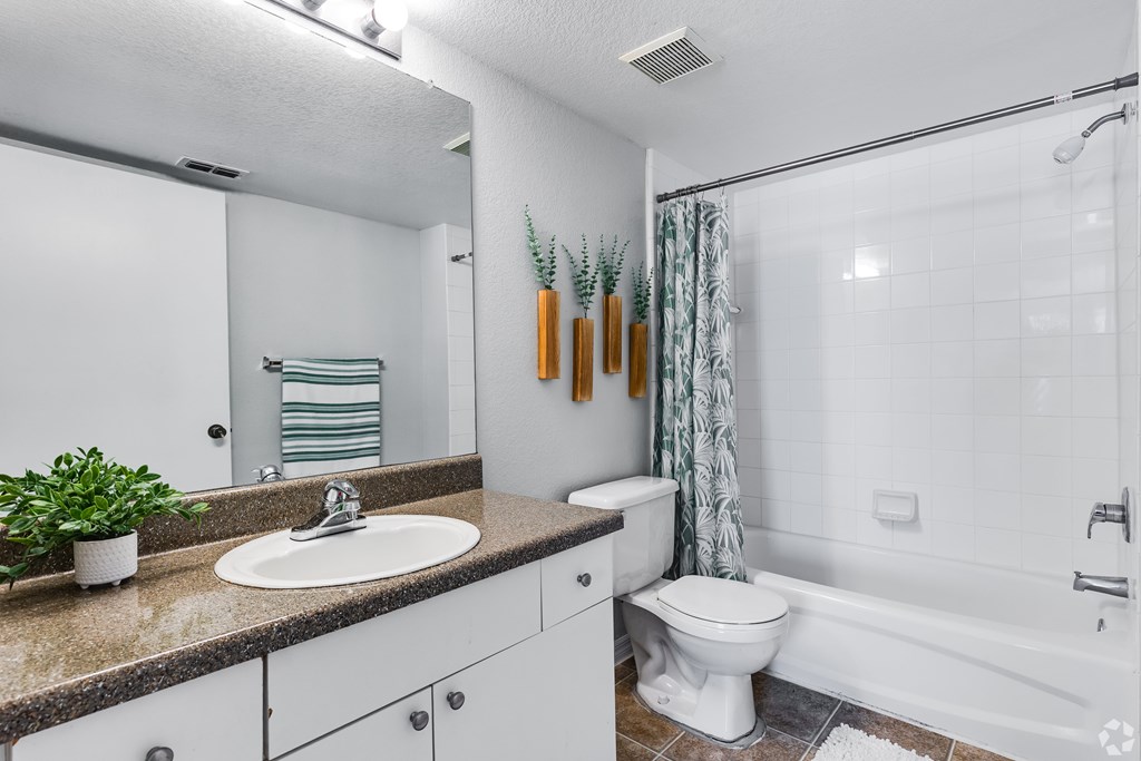 A bathroom with a white toilet, sink, and bathtub.