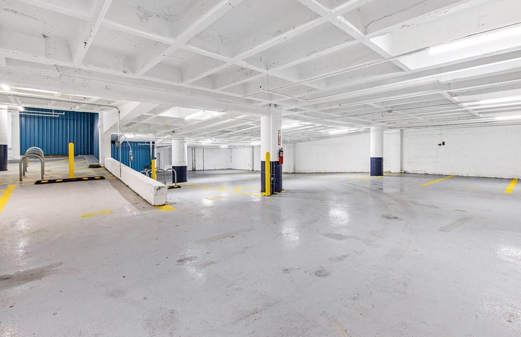 the interior of a parking garage with concrete floors and white walls and blue doors