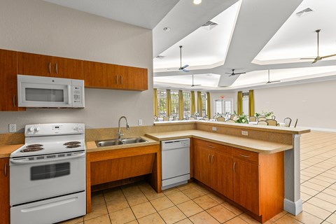 A kitchen with a white stove and a white microwave.