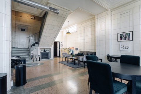 A living room with a black chair in front of a table.