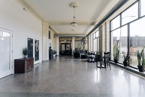 A spacious room with a long table and chairs, large windows, and a view of the outdoors.