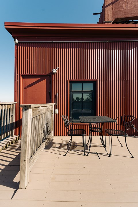 A red building with a table and chairs outside.