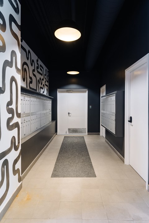 A hallway with a black ceiling and a white door.