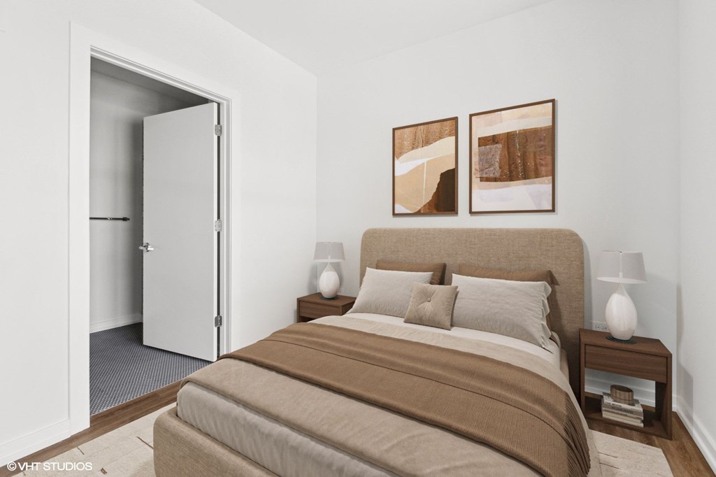 A bedroom with a large bed and two framed pictures on the wall.